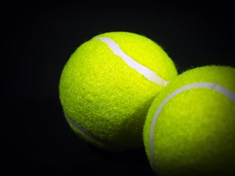 Vibrant close-up of two bright green tennis balls showing texture and detail.