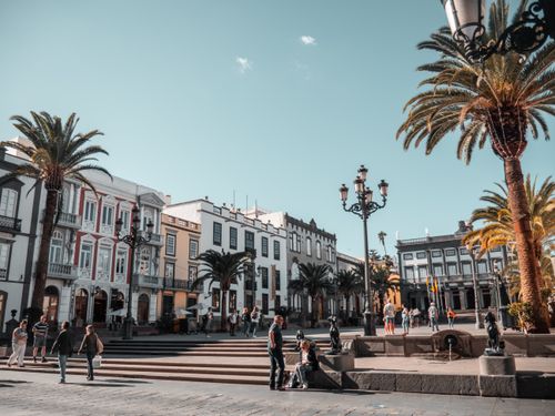 Free A vibrant day in a city square with people and palm trees in Canary Islands, Spain. Stock Photo