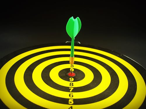 Free Green Dart Pointed to Dartboard Stock Photo