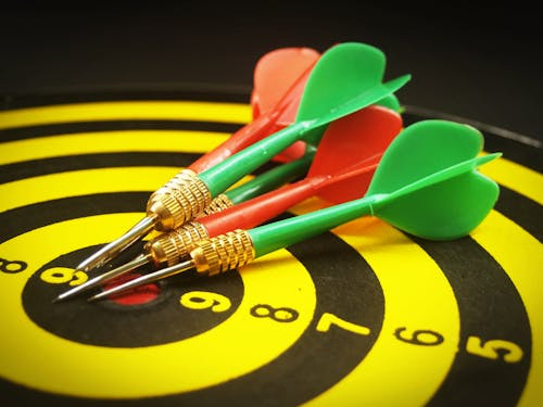 Yellow and Black Dartboard With Pins Illustration