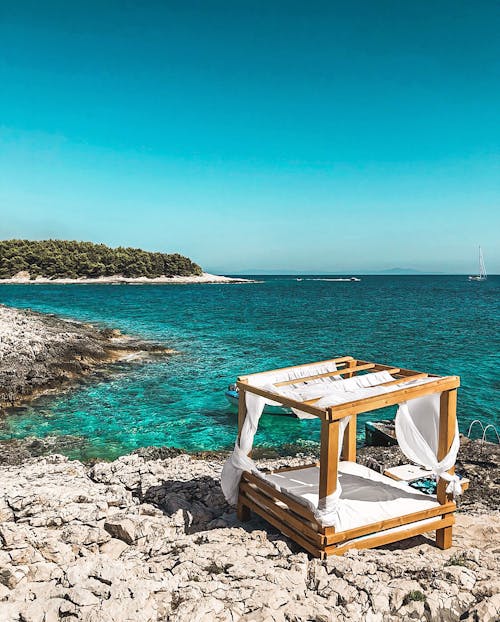 Белый и коричневый деревянный стол на берегу моря