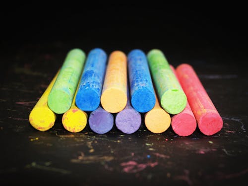 Pile of Colored Chalk on Black Wooden Tabletop