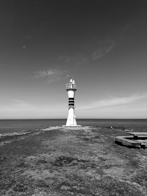 Black and white photo of lighthouse on the beach