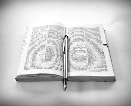 Grayscale Photography of Click Pen on Top of Opened Book