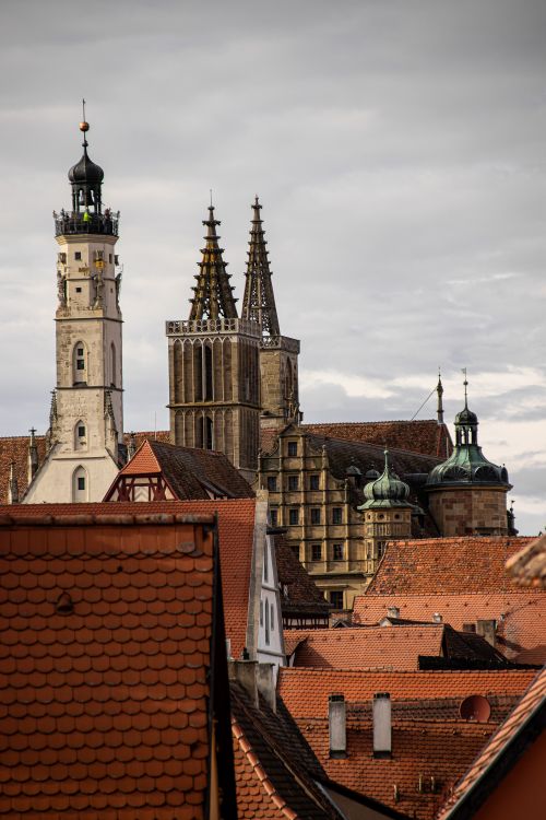 Free A scenic view of Gothic towers in Rothenburg framed by traditional red rooftops. Stock Photo
