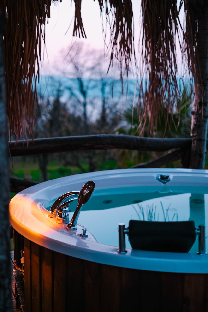 A tranquil hot tub retreat in an outdoor garden setting at twilight, promising ultimate relaxation.