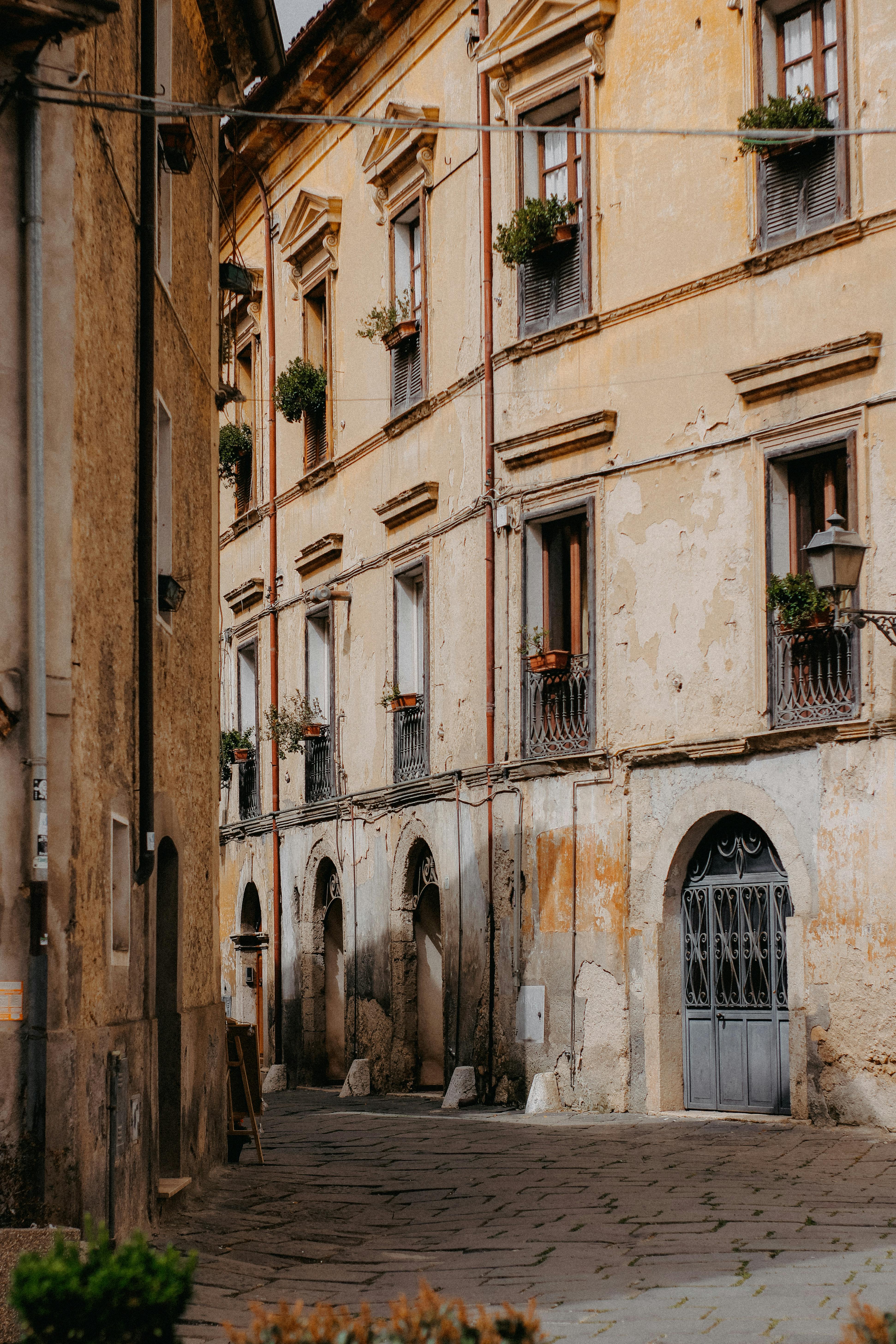 A narrow urban alley lined with historic vintage buildings and decorative windowsills.