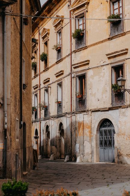 A narrow urban alley lined with historic vintage buildings and decorative windowsills.