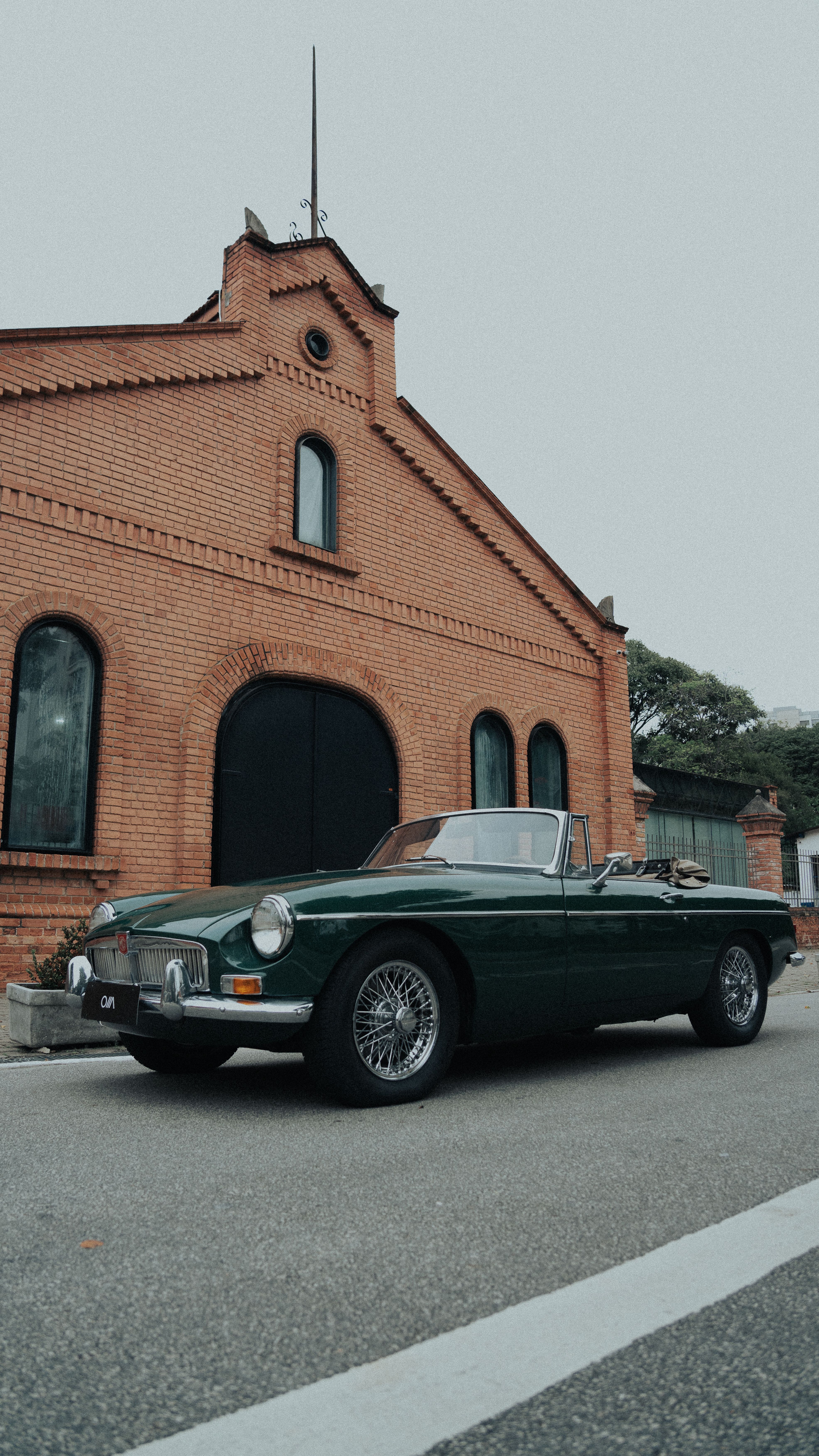 Classic MG MGB car parked by historic building in São Paulo, offering a vintage urban vibe.