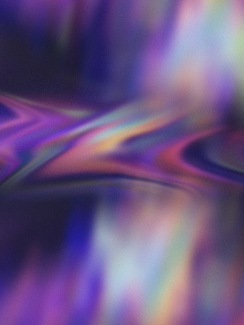 Dynamic abstract image with a blend of vibrant colors and blurred shapes creating a flow-like pattern.