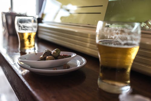 Olives and draft beer on a wooden counter