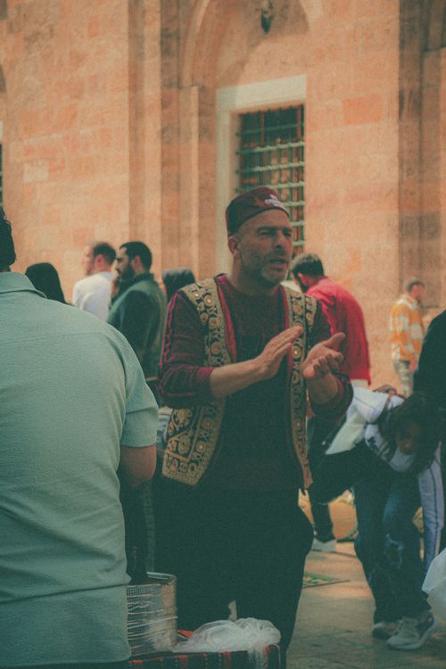 Free Man in traditional clothing performs in a bustling street market in Turkey. Stock Photo
