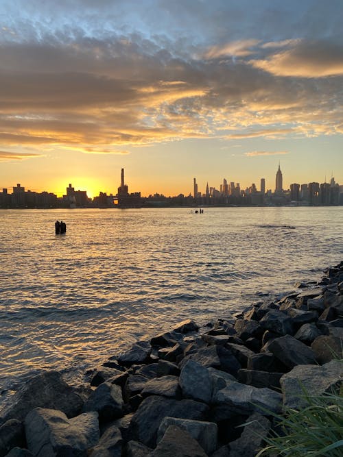 A sunset over the water with the city skyline in the background