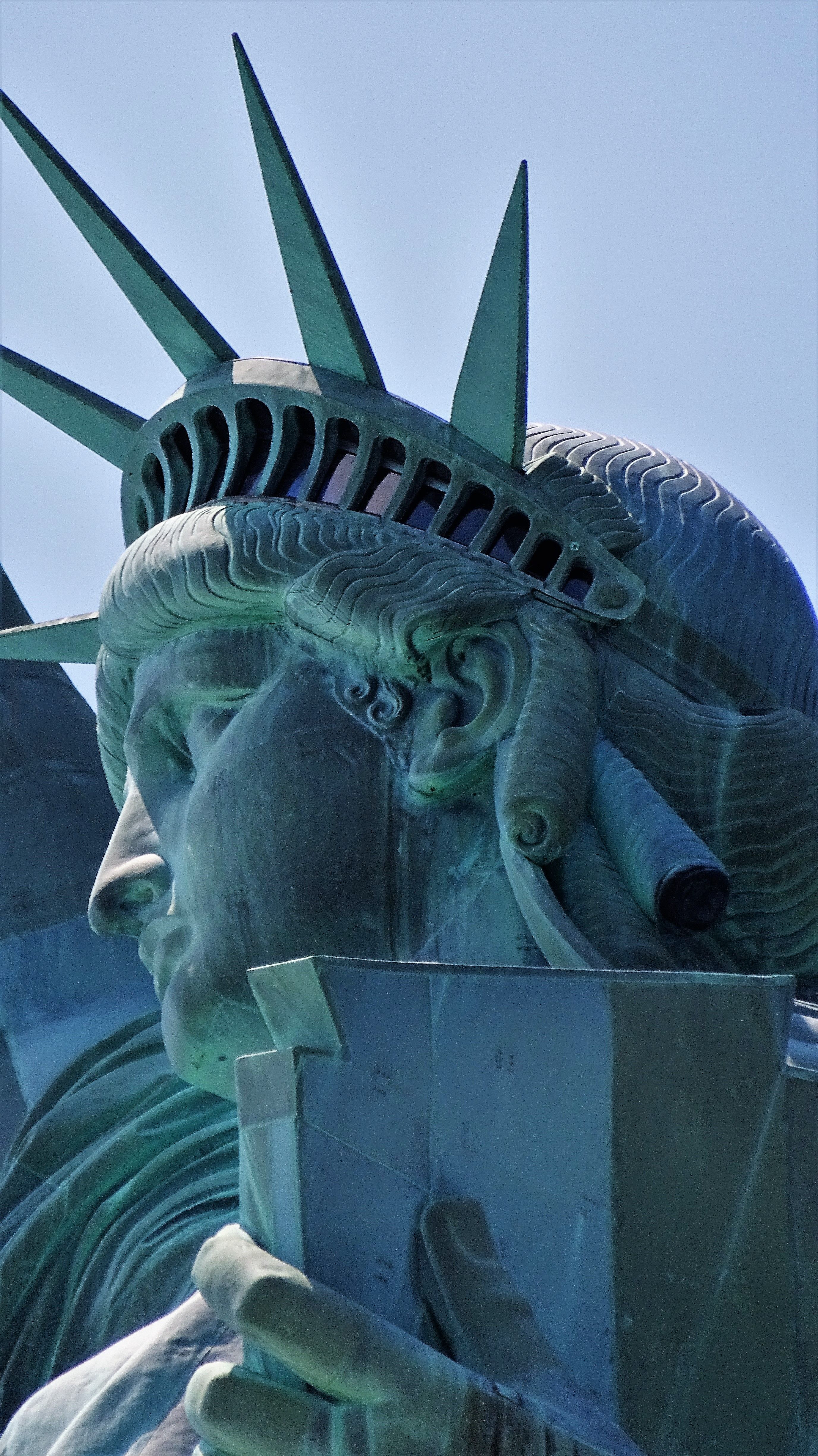 Detailed close-up view of the Statue of Liberty's face and crown in New York City.