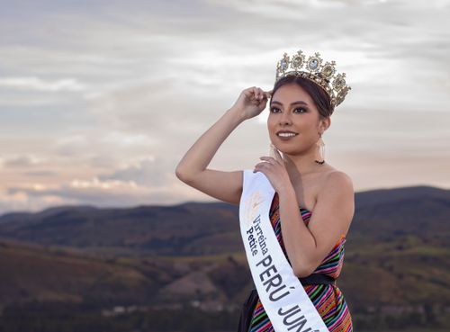Free A stunning Peruvian beauty queen poses with her crown against a scenic sunset in Junín. Stock Photo
