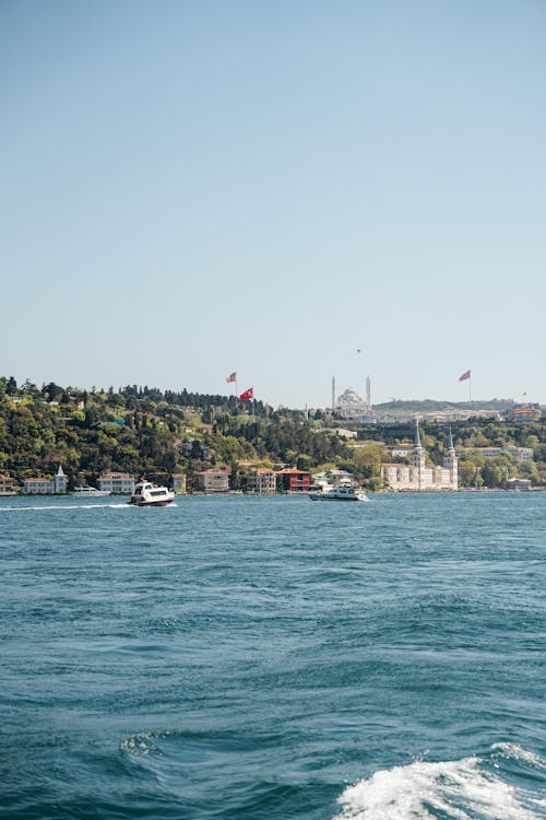 A boat is traveling through the water with a view of the city