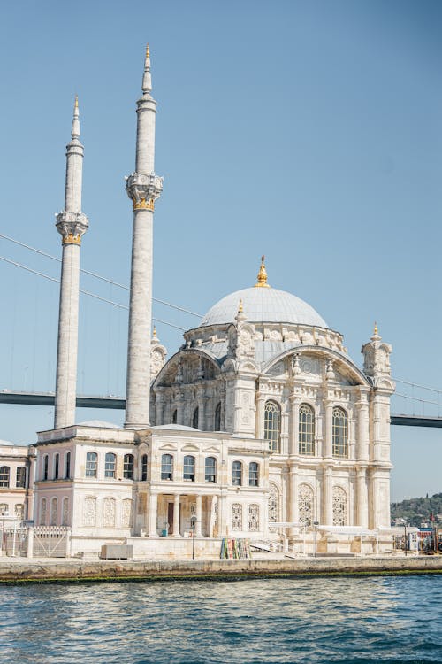 A white mosque with a bridge in the background