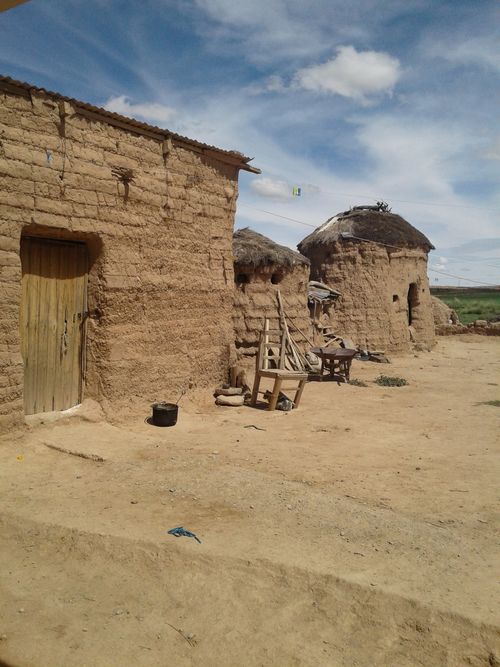 Free Scenic view of traditional clay and thatched-roof houses in a rural village setting. Stock Photo