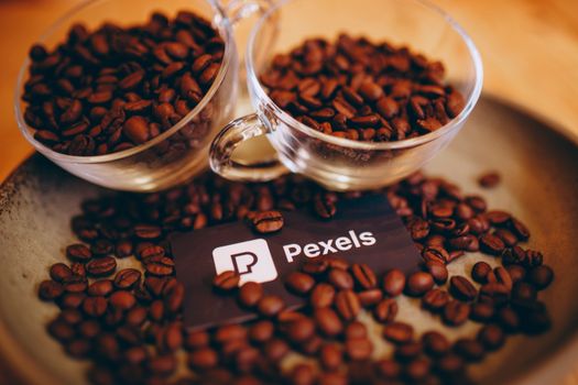Coffee beans in glass cups set on a ceramic plate, creating a warm autumn feel.
