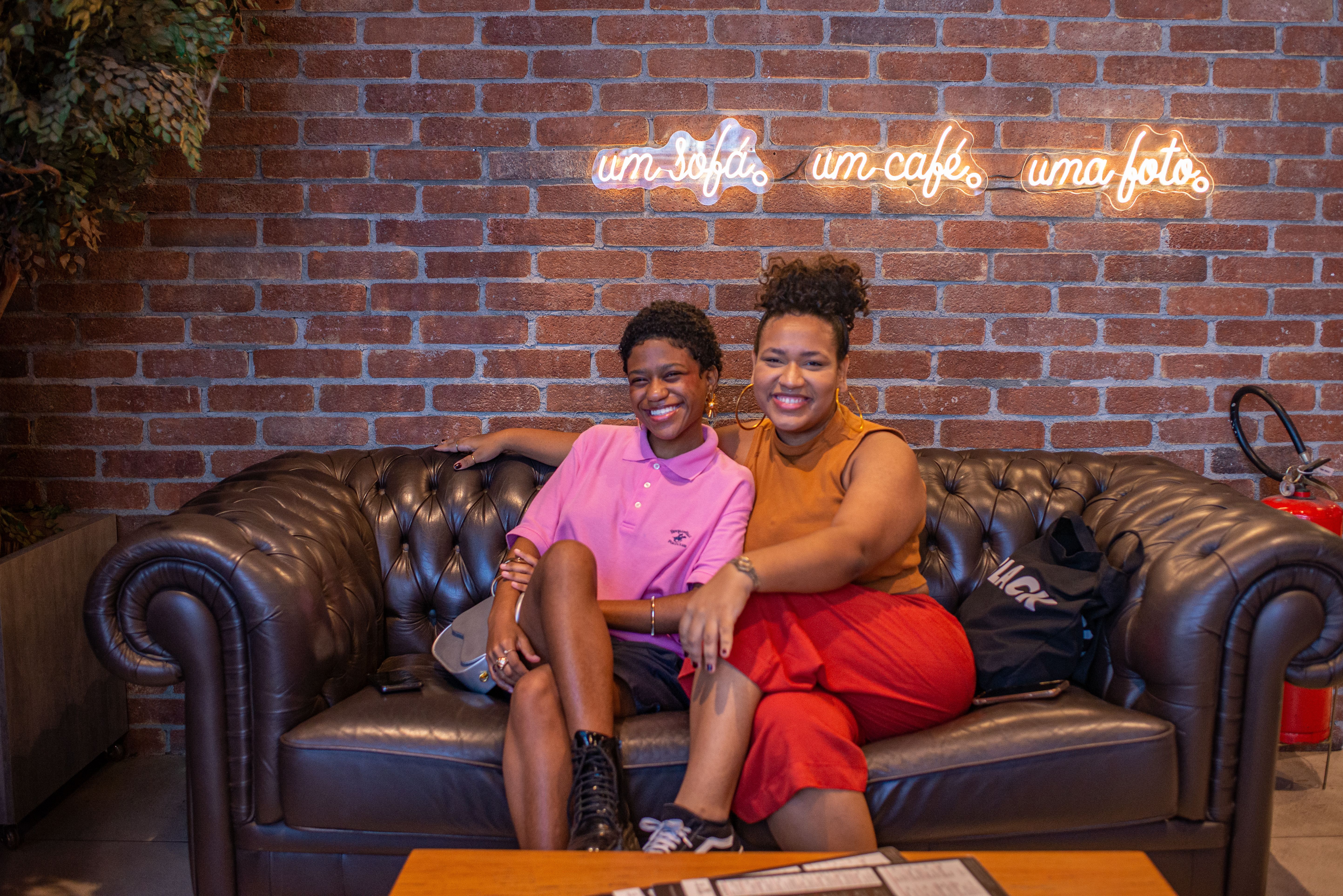Smiling Women Sitting on Sofa in Cafe · Free Stock Photo