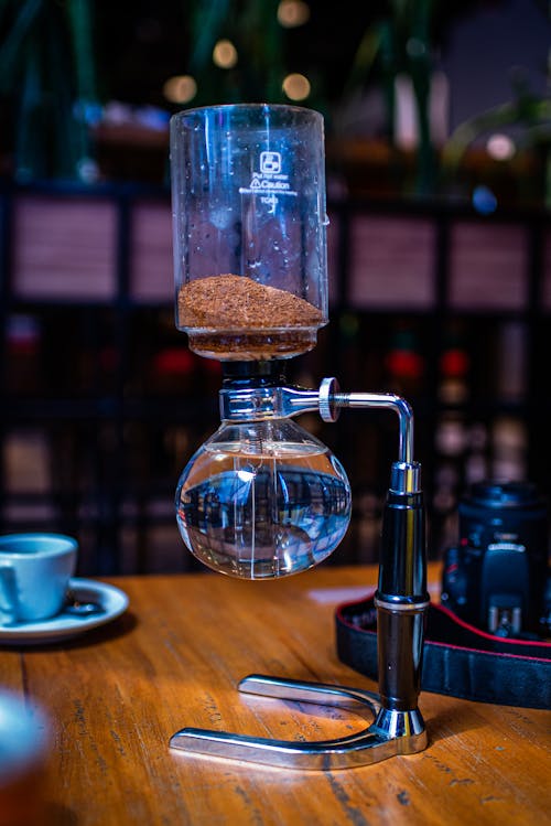 A coffee maker with a glass of water on top