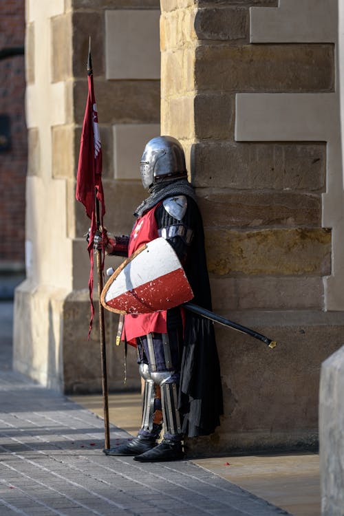 Homme Portant Une Armure Grise Et Rouge Debout Dans Les Rues