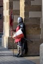 Man Wearing Gray and Red Armour Standing on the Streets