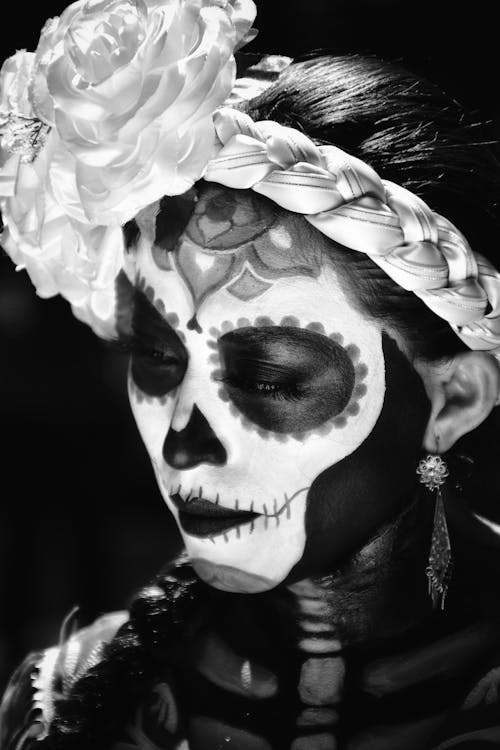 A woman with a skull face paint and flowers in her hair