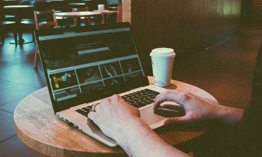 person typing laptop cafe coffee
