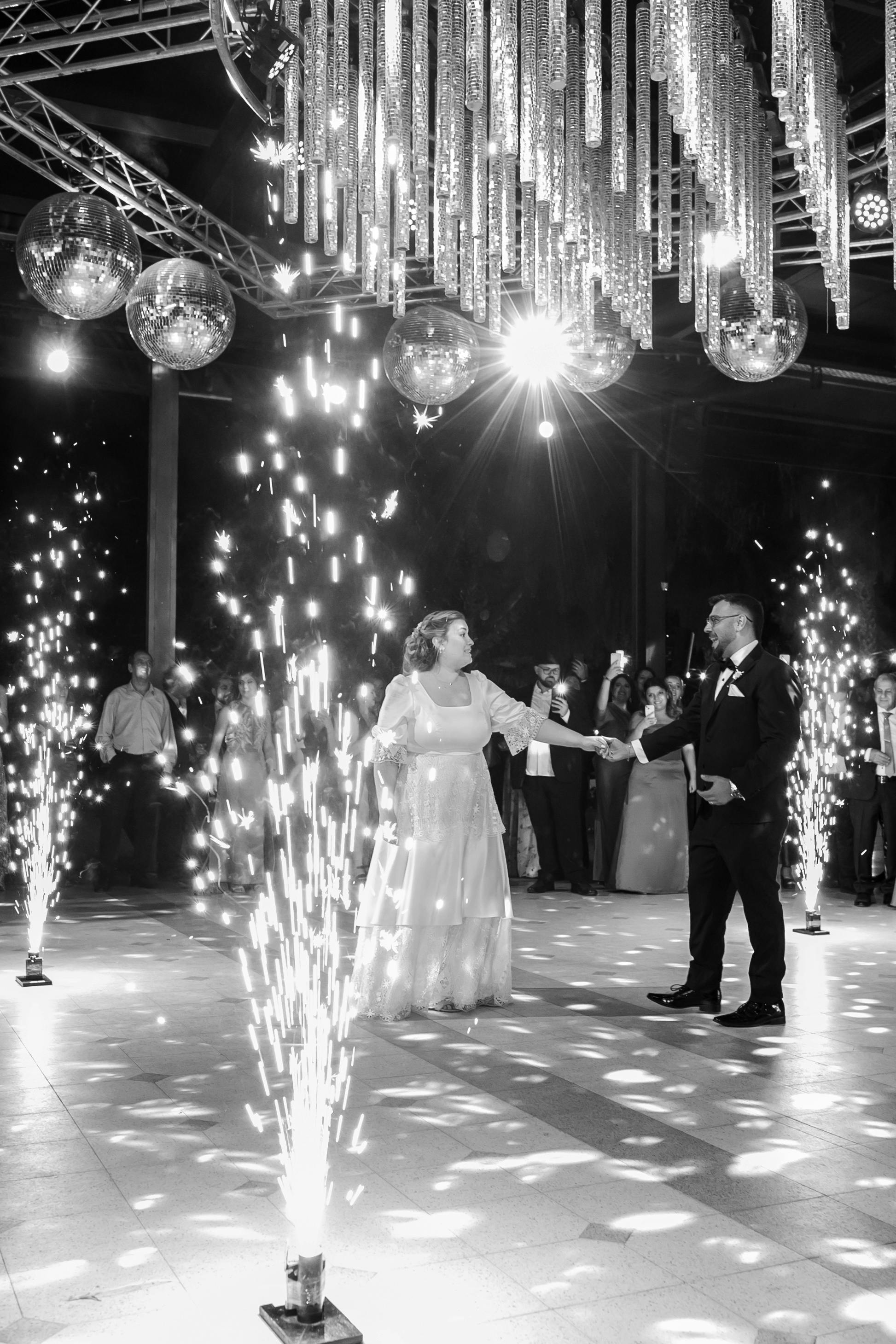 newlyweds dancing on floor among sparkles