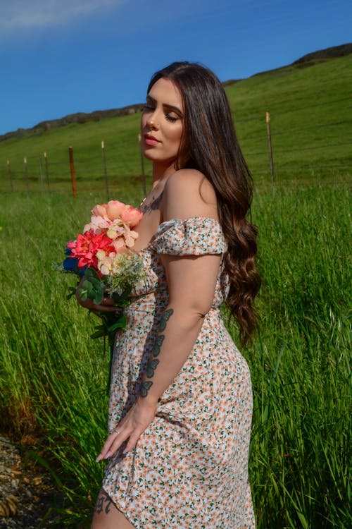 A woman in a floral dress holding a bouquet