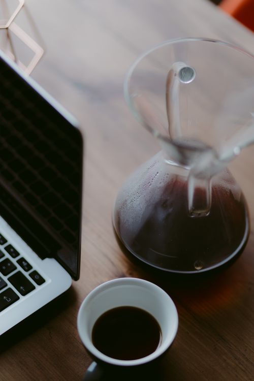 Free Warm desk view with a Chemex brewer and black coffee, perfect for productivity. Stock Photo