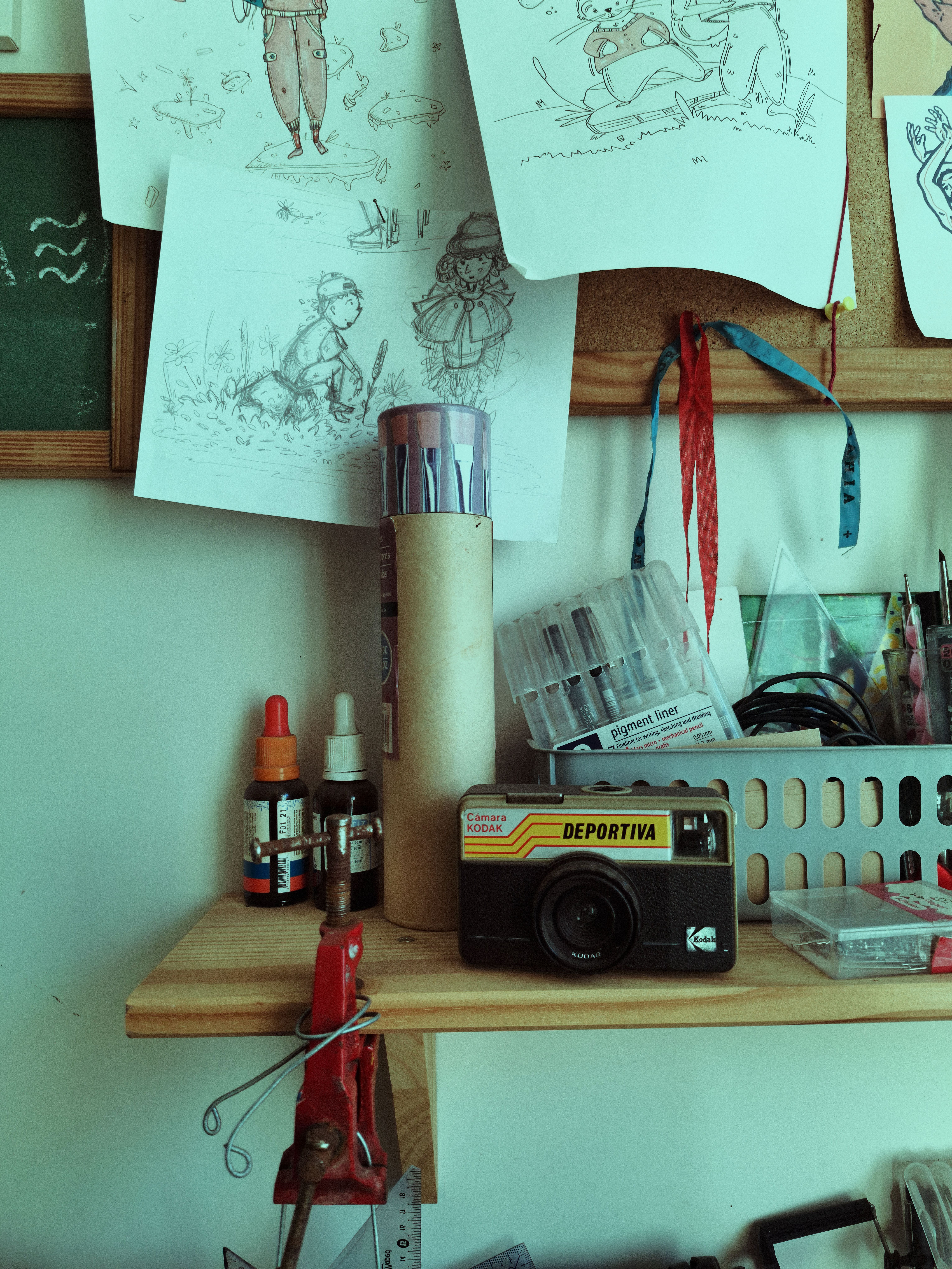 A creative workshop featuring a vintage camera and art supplies on a wooden shelf.