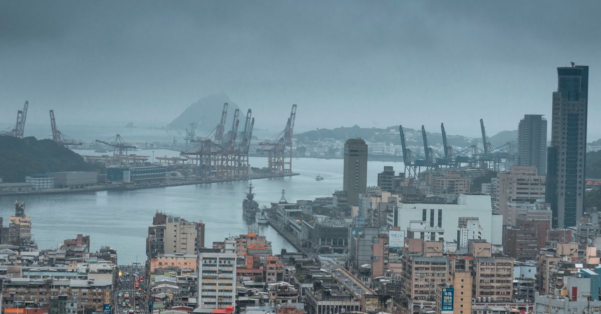 Aerial view of Keelung Harbor showcasing urban sprawl and cranes under cloudy skies.