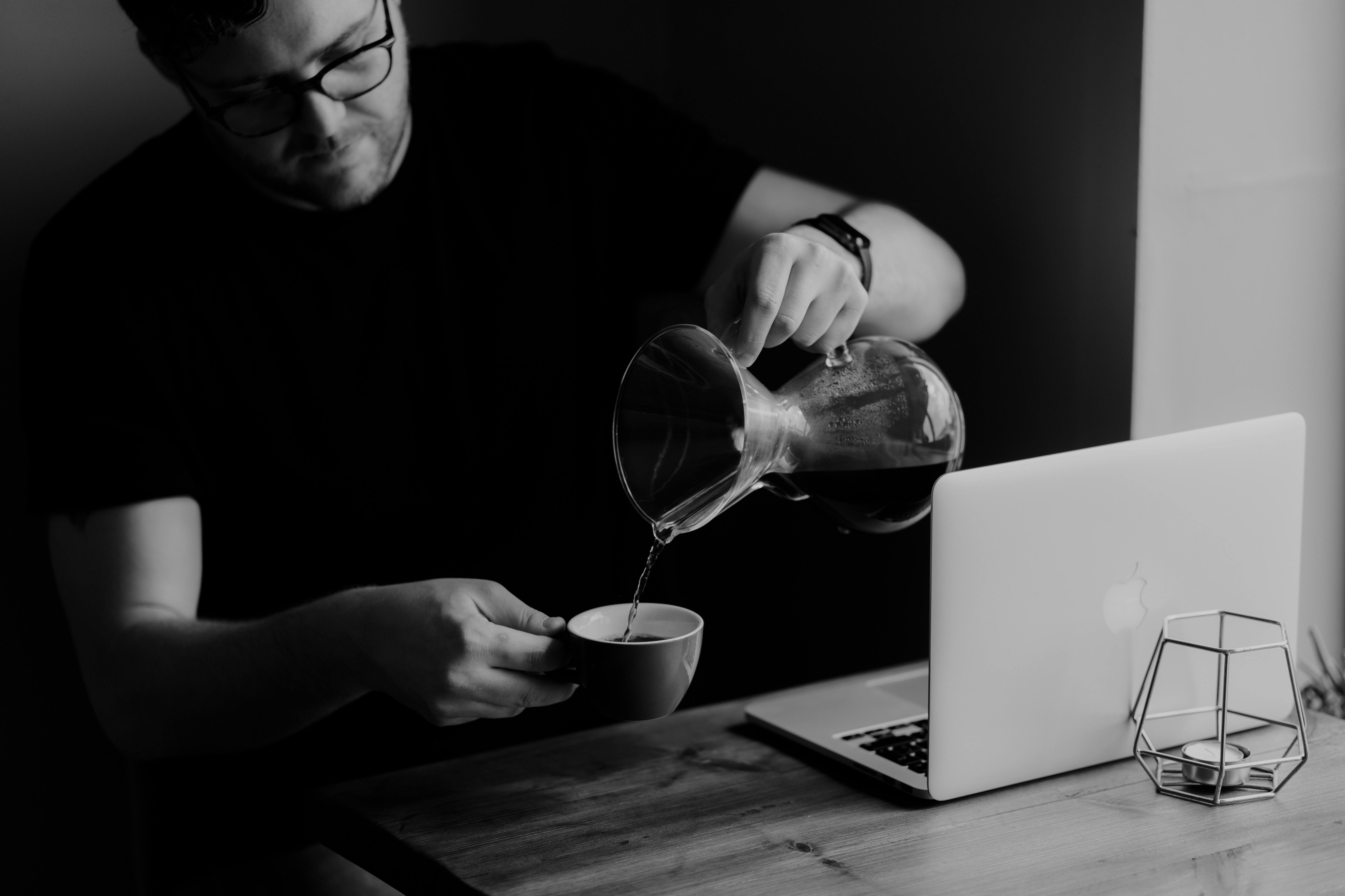 man pouring liquor into cup