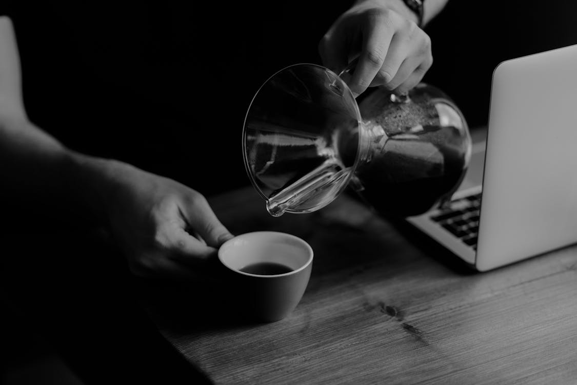 Person Pouring Beverage In Cup