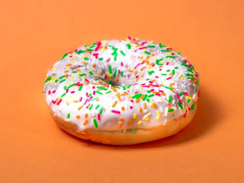 Glazed donut with colorful sprinkles.