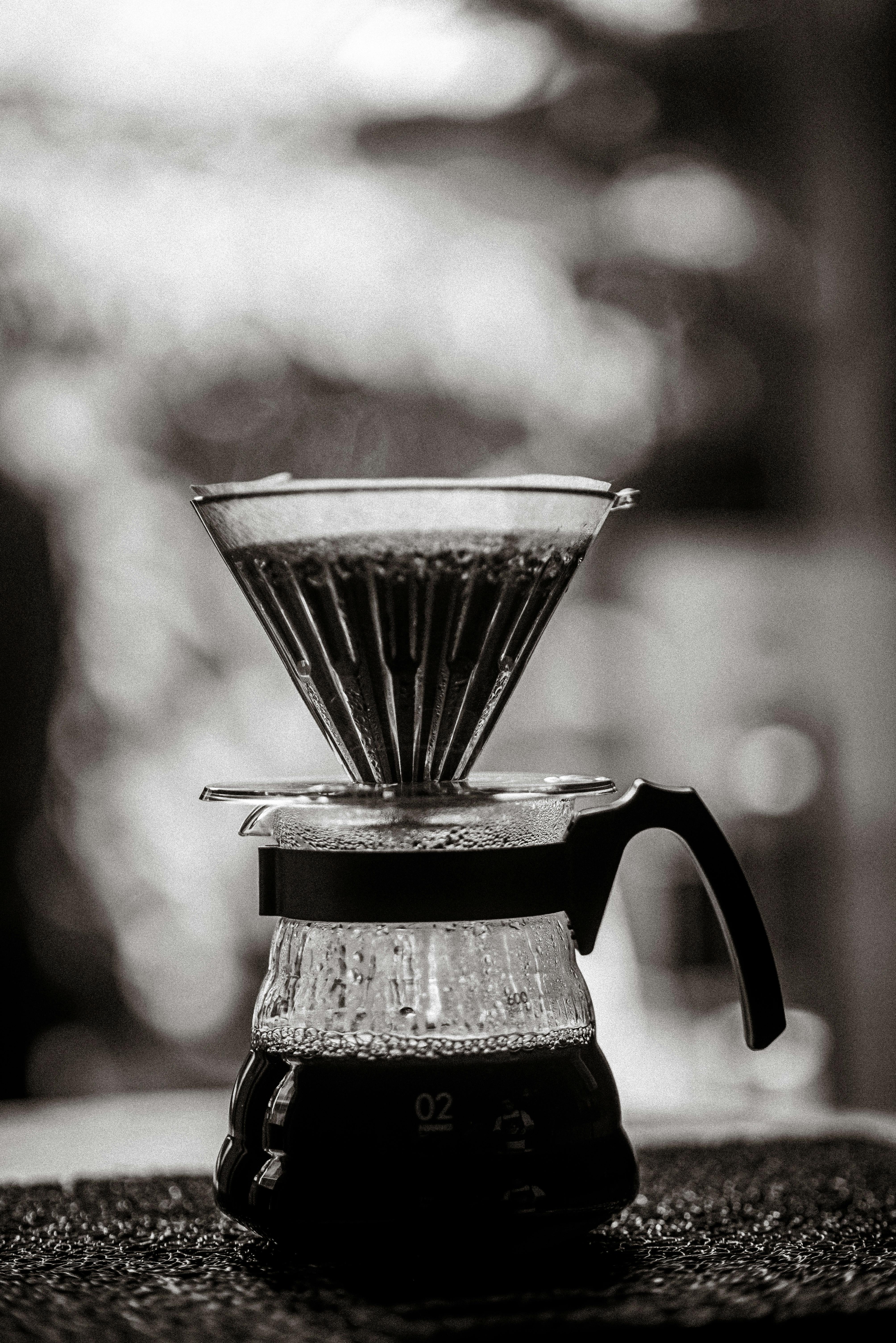 Classic pour over coffee maker with steaming coffee in black and white.