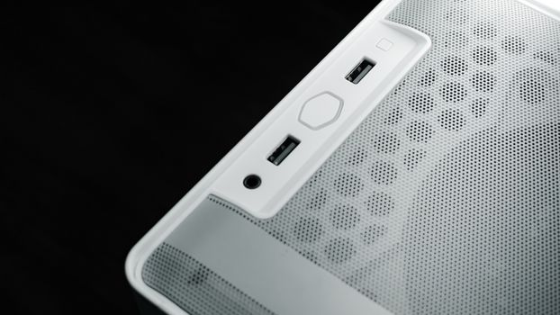 Detailed view of USB and audio ports on a white computer case, showcasing modern technology design.