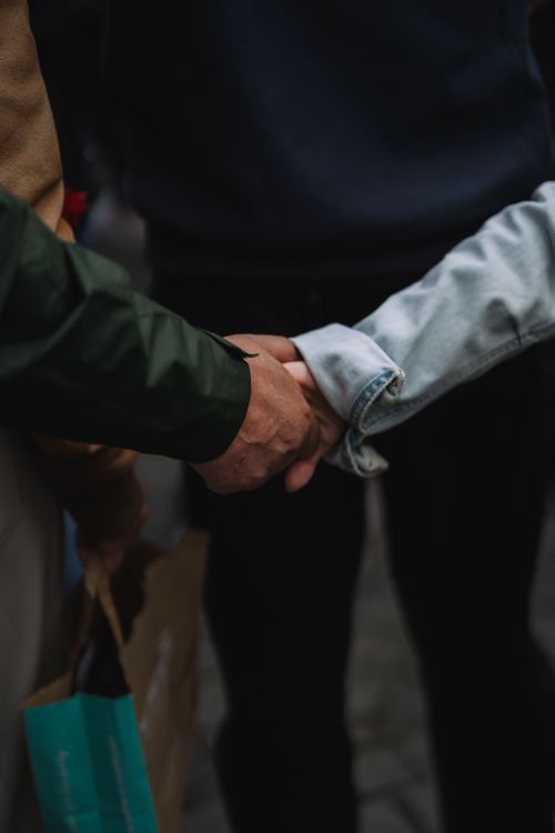 Free A close-up shot of two individuals shaking hands outdoors, signifying unity and agreement. Stock Photo