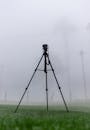 雾蒙蒙的田野上，一个寂静的三脚架静静矗立，唤起一种神秘而宁静的心情