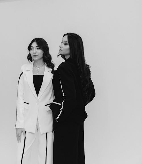 Two women in black and white suits standing next to each other