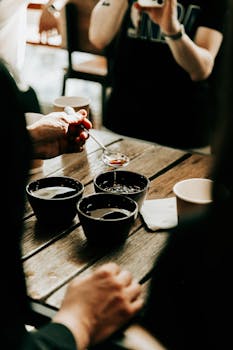 Close-up of hands holding a spoon during a coffee tasting session in Baku, Azerbaijan.