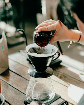 Close-up of manual pour over coffee brewing with a barista in Baku café.