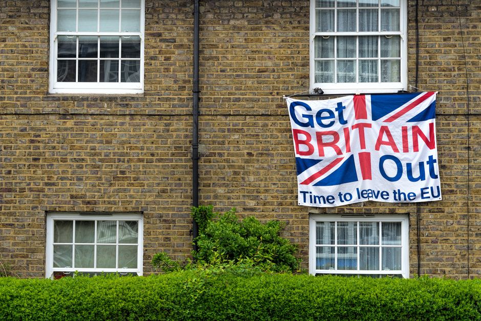 Brick home displaying Brexit protest sign with Union Jack design.
