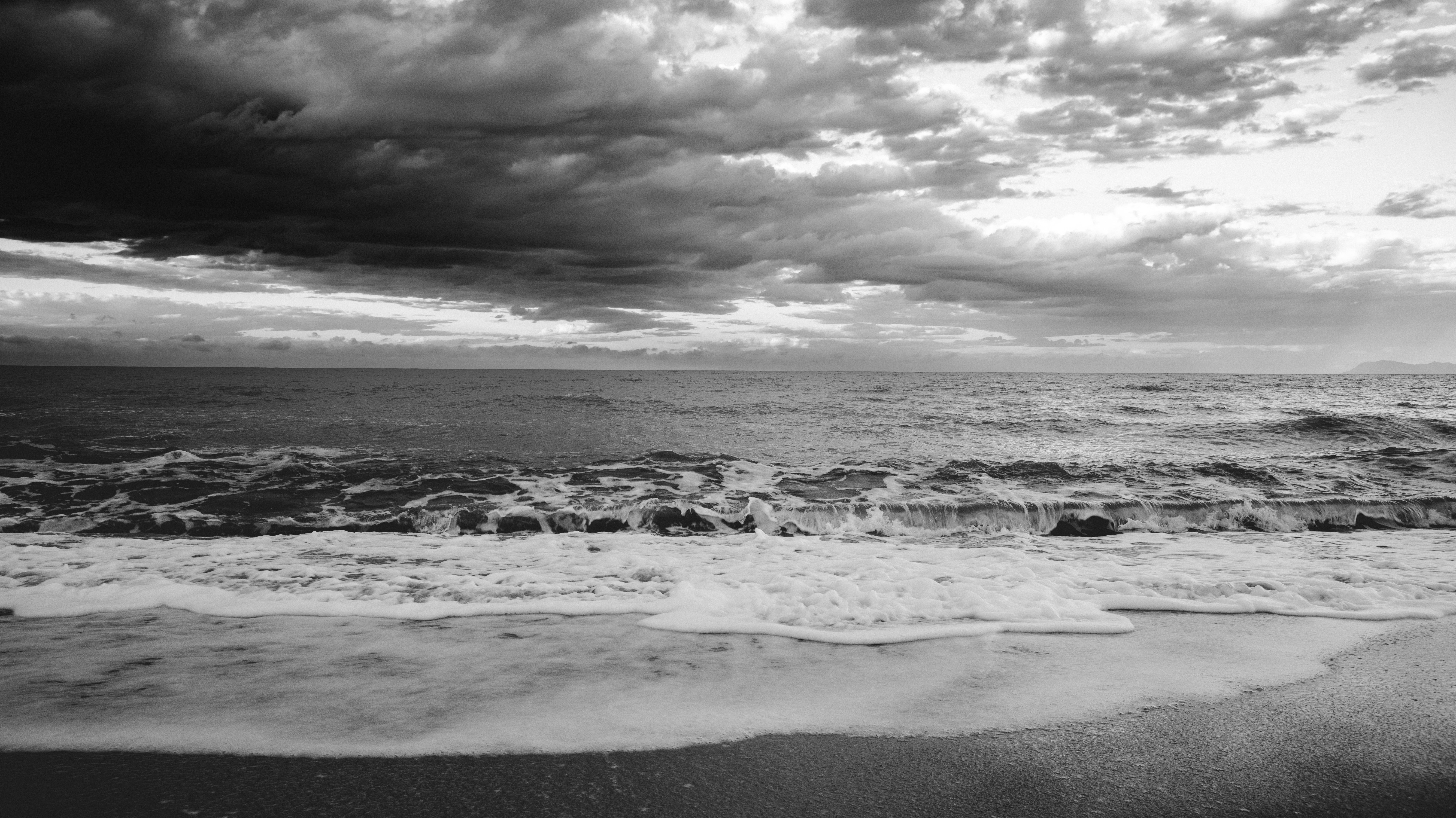 Black and white photo of the ocean with clouds · Free Stock Photo