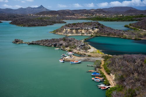 Aerial Photography of Boats Beside Road Under Blue Sky