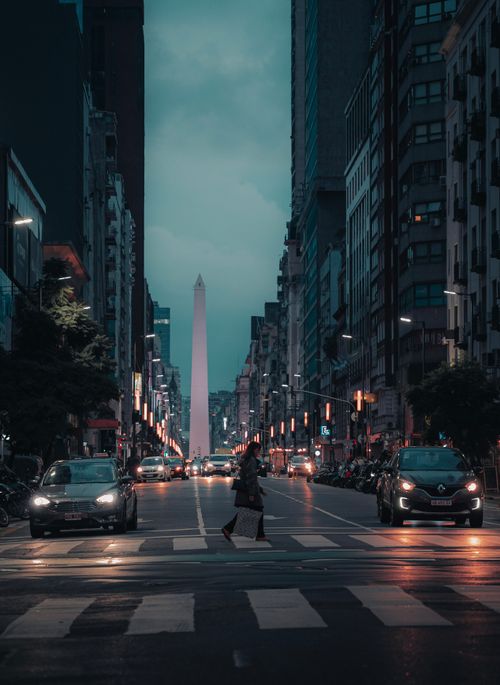 Free Dramatic night view of Buenos Aires city street, showcasing the iconic Obelisk illuminated amid urban architecture. Stock Photo
