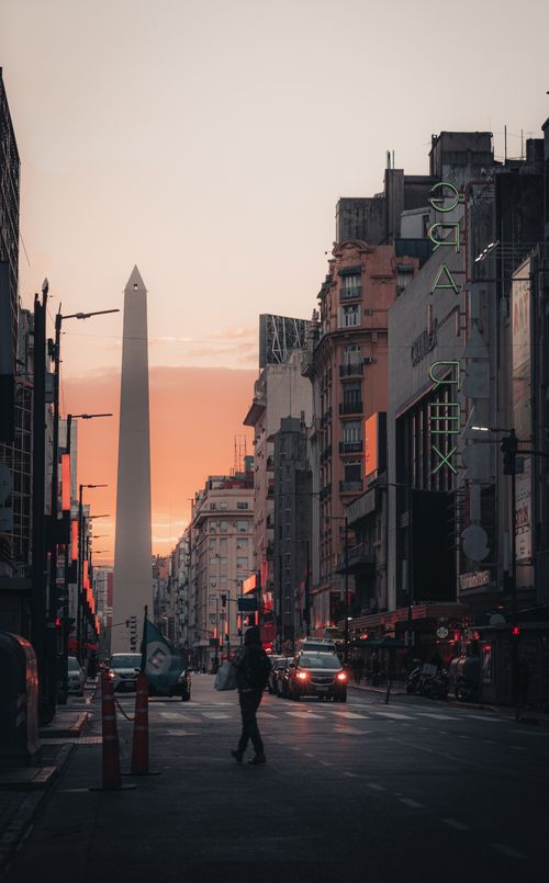 Free View of the Buenos Aires Obelisk against a sunset sky, capturing the vibrant city life. Stock Photo