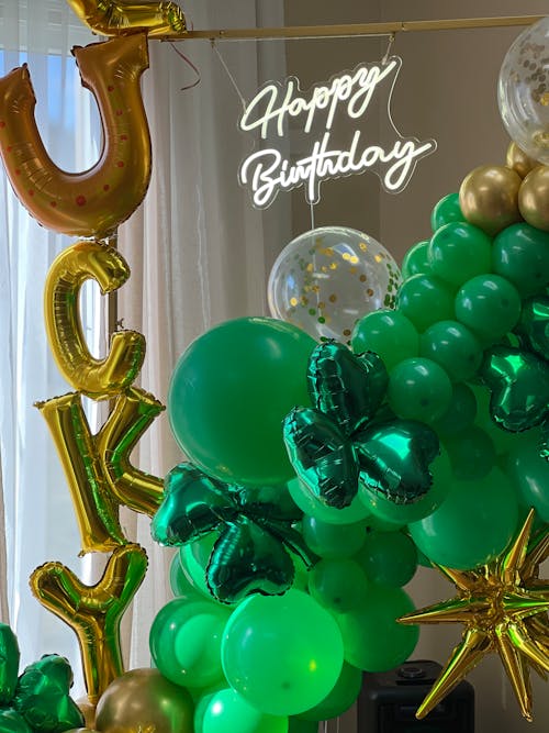 A green and gold balloon arch with shamrock decorations